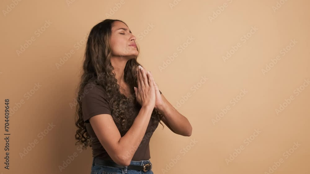 An hispanic woman closing eyes and praying An hispanic woman closing eyes and praying