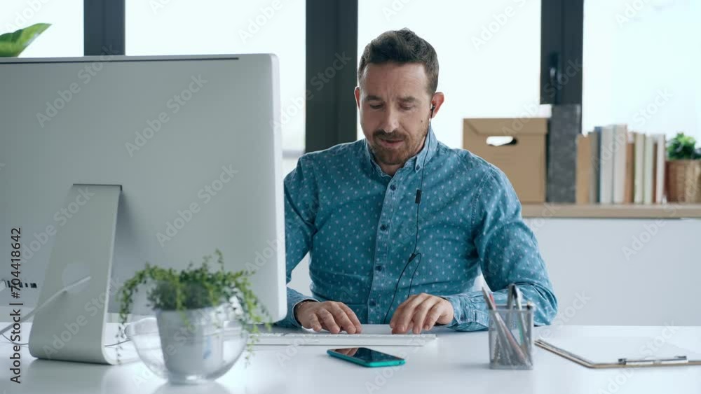 Video of business man making video call with computer while talking with earphone sitting in modern startup office. Video of business man making video call with computer while talking with earphone sitting in modern startup office.
