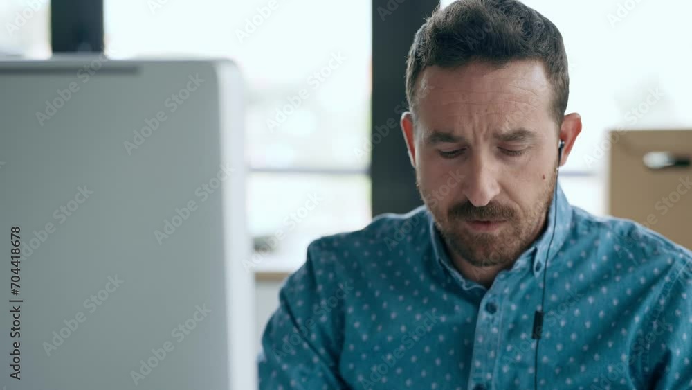 Video of business man making video call with computer while talking with earphone sitting in modern startup office. Video of business man making video call with computer while talking with earphone sitting in modern startup office.