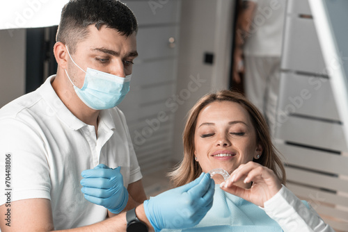 Dentist holds aligner aligner in hands, preparing for important stage treatment and providing comfort to patient. Explains and demonstrates benefits aligner aligners for correcting alignment teeth
