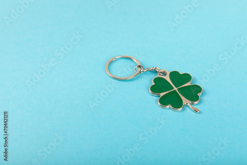 Clover keychain with key ring on a colored background. Concepts for real estate and moving home or renting property. Buying a property. Mock-up keychain.Copy space.