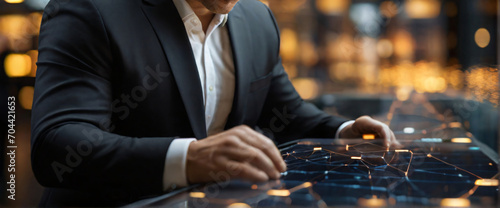 A businessman holding a tablet and looking at a virtual blockchain network with data fields floating around him. A close up shoot of hands and tablet, using a Canon EOS 5D Mark IV with a 70-200mm f/2.