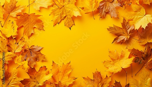 The fall composition is in the form of a square bordered by bright maple leaves on a yellow background. Seasonal concept mock-up, Textured Autumn leaf background with room for copy space.
