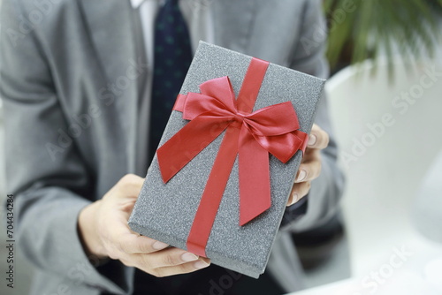Midsection of businessman holding gift box