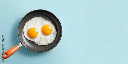 Fried egg sizzling on a black pan isolated pastel background. Copy space