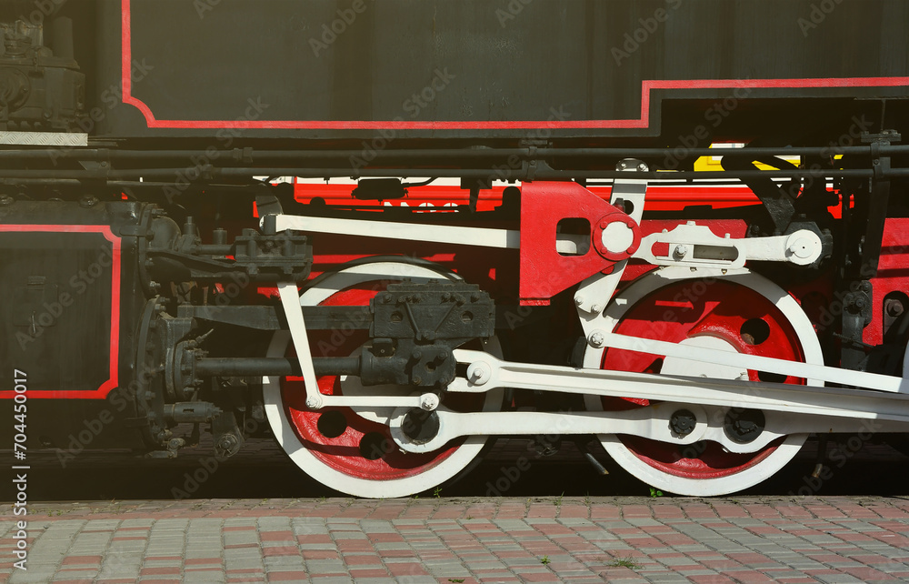 Wheels of the old black steam locomotive of Soviet times. The side of ...