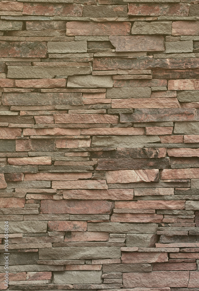 Texture of a stone wall from long and rough stones of different sizes and tones Texture of a stone wall from long and rough stones of different sizes and tones