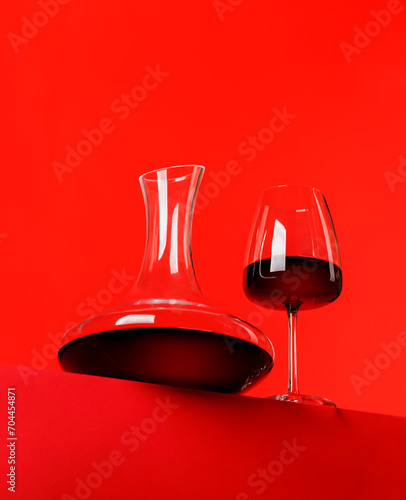 Bild auf Leinwand Red wine elegance: Decanter against a vibrant red background