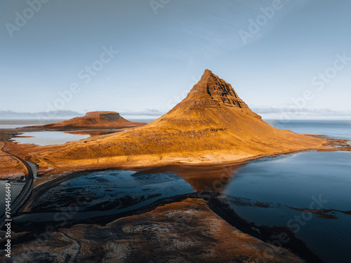Beautiful aerial view of the Kirkjufell high mountain in Iceland, on the Snaefellsnes peninsula. Sunset Sunrise soft orange light. West Iceland.