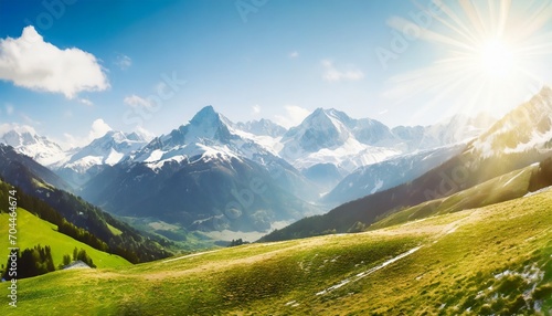 idyllic landscape in the alps with snow capped mountain tops in the background