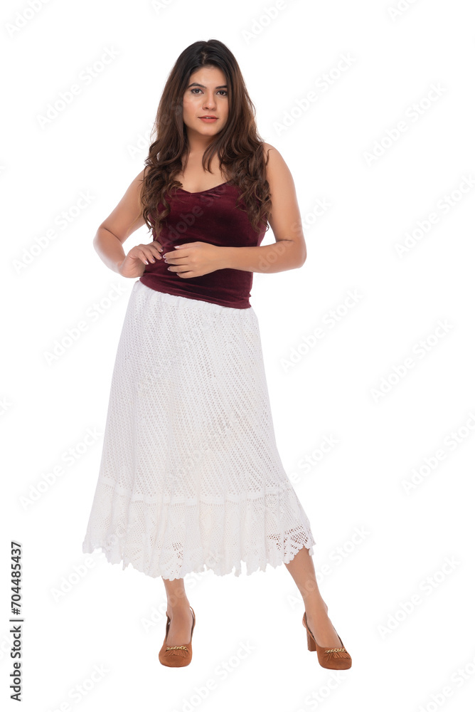 Fototapeta premium Young Indian girl wearing red velvet top and white crochet skirt with elegant pose and expression