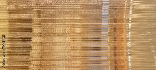 gold glass sheet wall or corrugated wall pattern texture use as background. frosted wave glass in horizontal line pattern in the translucent and polished effect.
