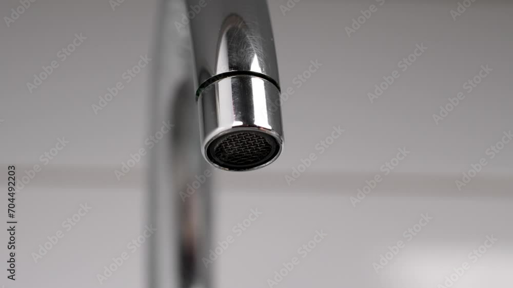Short turning on and off of a kitchen chrome faucet. Save water concept Short turning on and off of a kitchen chrome faucet. Save water concept