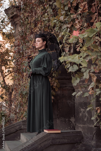 A woman is standing in the park. Girl with a lace umbrella.