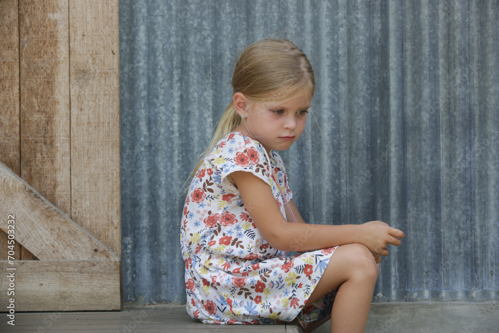 Annoyed little girl sitting on the street steps Annoyed little girl sitting on the street steps