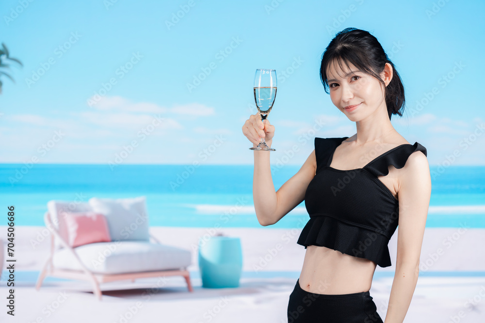 ビーチでスパークリングワインを飲む若い女性