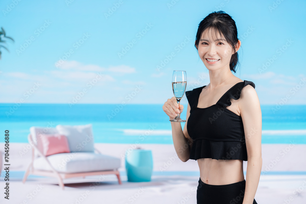 ビーチでスパークリングワインを飲む若い女性 ビーチでスパークリングワインを飲む若い女性