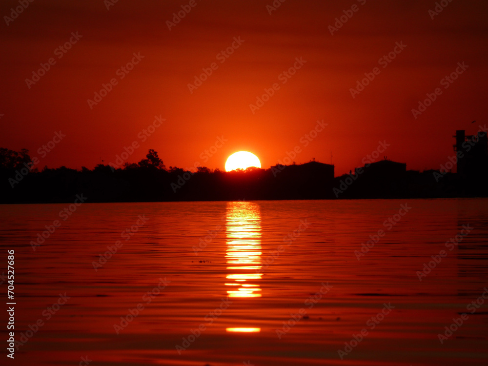 El sol de esconde detrás de los arboles costeros del río Coronda, perteneciente al delta del uno de los ríos mas grandes de Sudamérica como lo es el río Paraná.