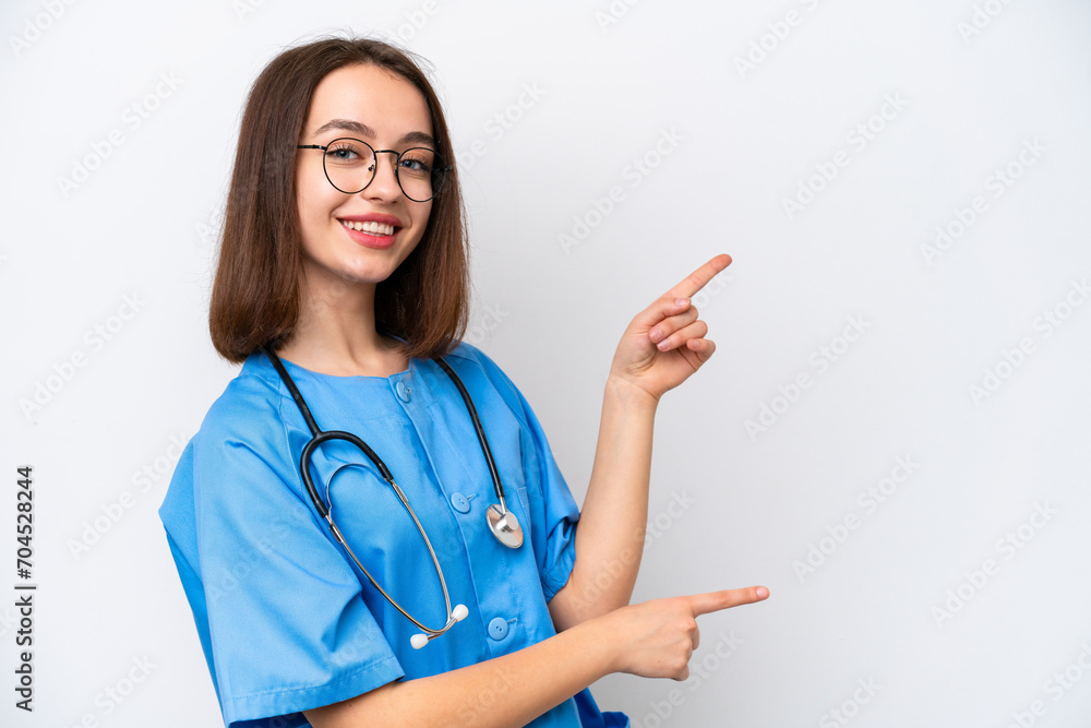Young nurse Ukrainian woman isolated on white background pointing finger to the side and presenting a product Young nurse Ukrainian woman isolated on white background pointing finger to the side and presenting a product