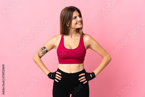 Young slovak woman isolated on pink background posing with arms at hip and looking side