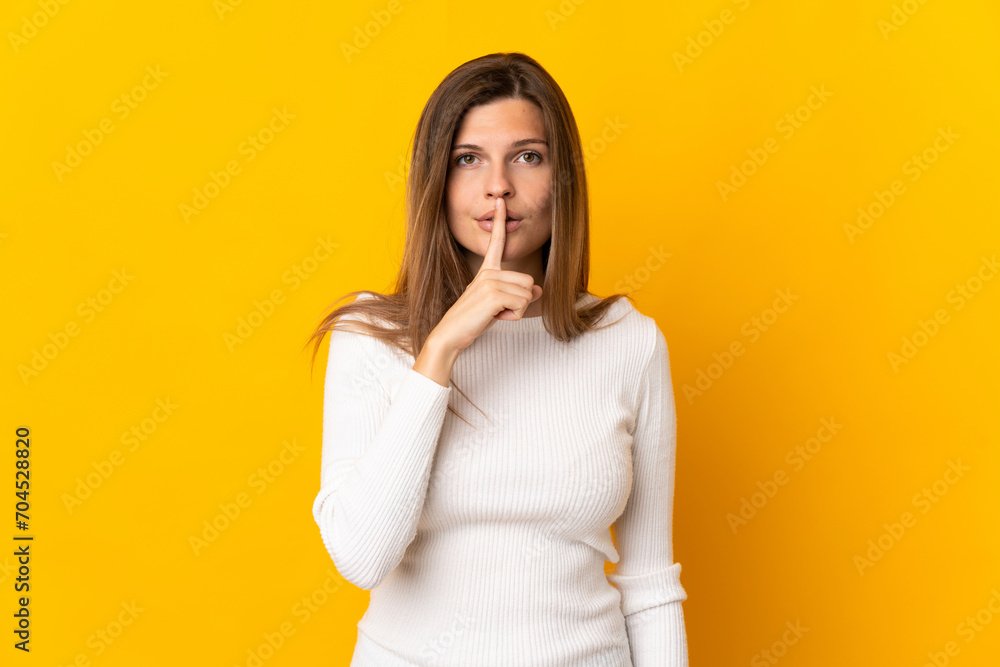 Young Slovak woman isolated on yellow background showing a sign of silence gesture putting finger in mouth Young Slovak woman isolated on yellow background showing a sign of silence gesture putting finger in mouth