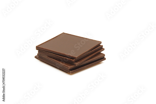 Stack of thin square pieces of chocolate isolated on white background.