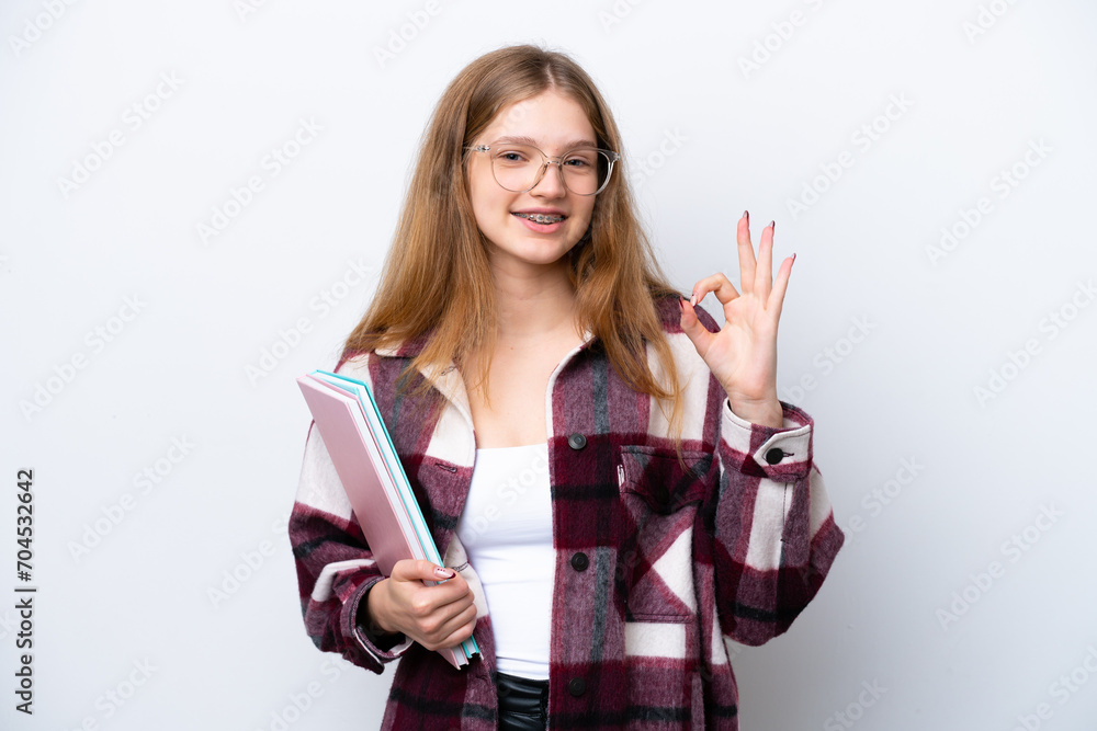 Teenager student Russian girl isolated on white background showing ok sign with fingers Teenager student Russian girl isolated on white background showing ok sign with fingers
