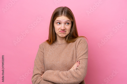 Teenager Russian girl isolated on pink background making doubts gesture while lifting the shoulders