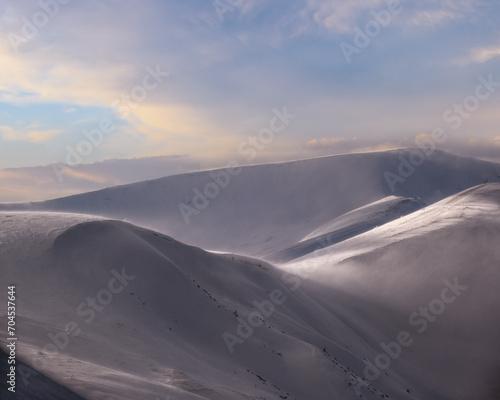 Snow covered winter mountains  in last evening sunlight. Magnificent windy dusk. © wildman