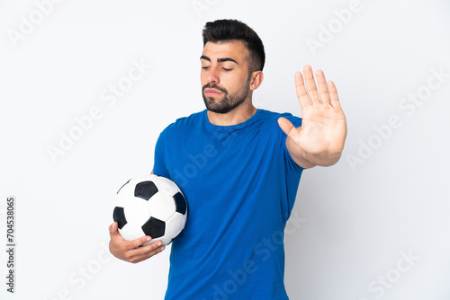 Handsome young football player man over isolated wall making stop gesture and disappointed