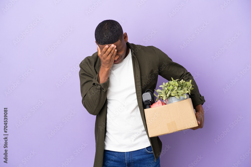 Latin man making a move while picking up a box full of things with tired and sick expression Latin man making a move while picking up a box full of things with tired and sick expression