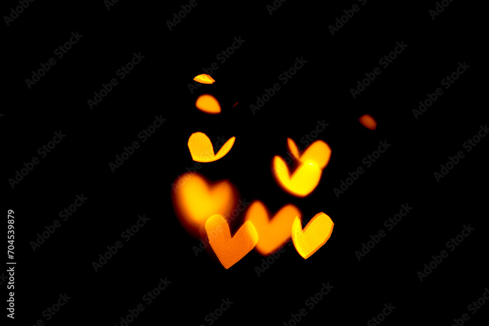 blurred bokeh withe hearts in golden, yellow colors on black background blurred bokeh withe hearts in golden, yellow colors on black background