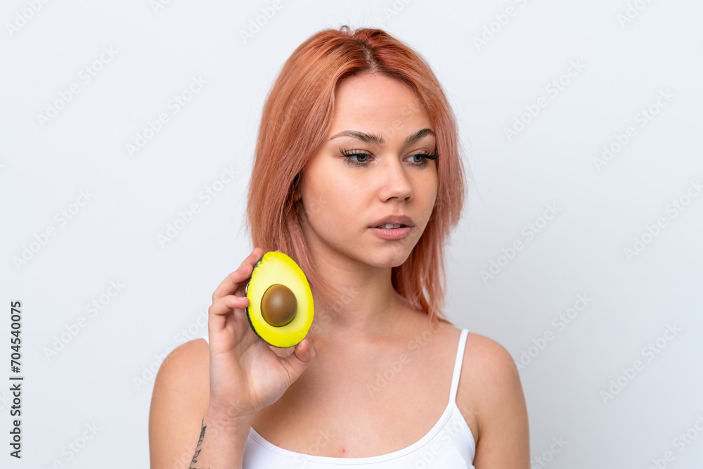 Young Russian girl isolated on white background holding an avocado. Close up portrait Young Russian girl isolated on white background holding an avocado. Close up portrait