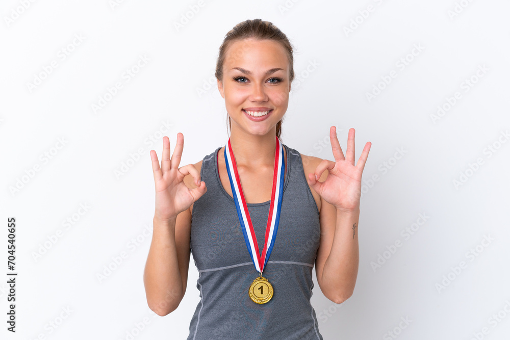 Young sport Russian girl with medals isolated on white background showing an ok sign with fingers Young sport Russian girl with medals isolated on white background showing an ok sign with fingers