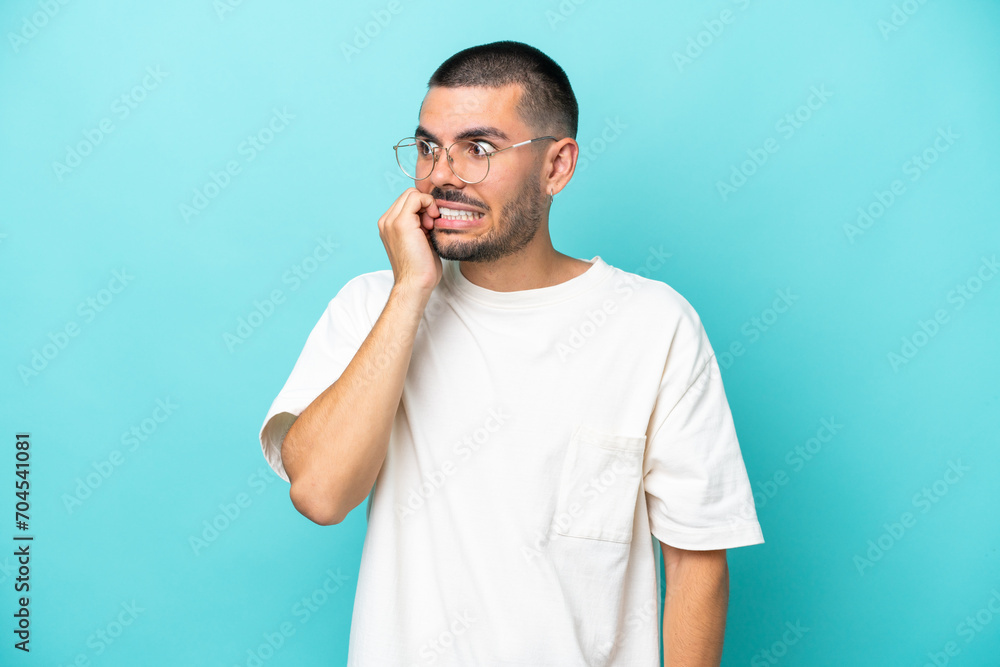 Young caucasian man isolated on blue background is a little bit nervous Young caucasian man isolated on blue background is a little bit nervous