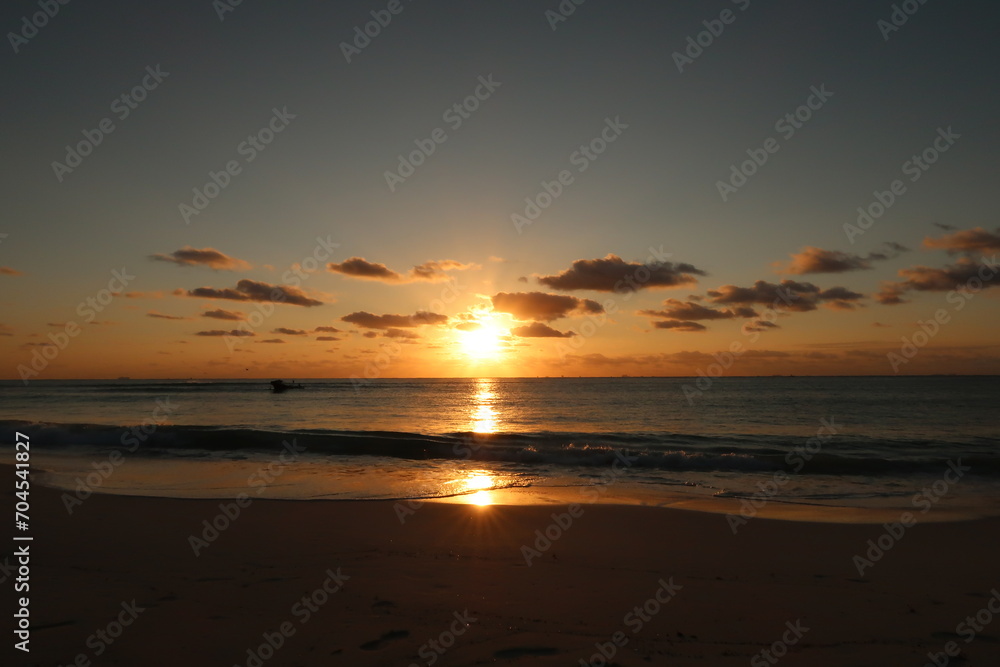 Sunrise and its reflection at the beach in playa del Carmen, Mexico