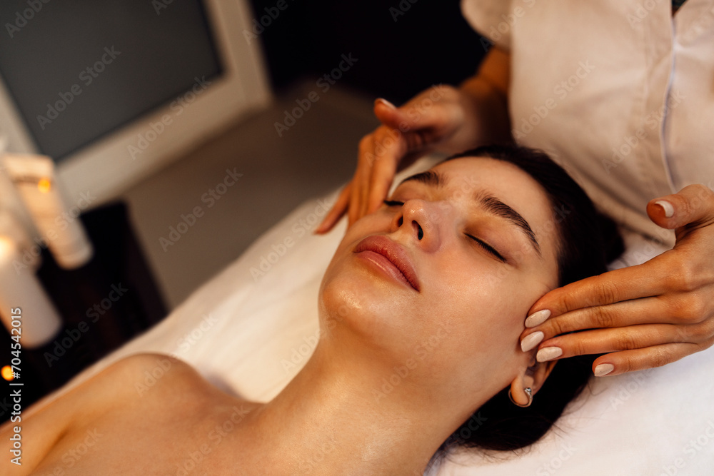 Close up portrait of a young beautiful woman getting facial massage Close up portrait of a young beautiful woman getting facial massage