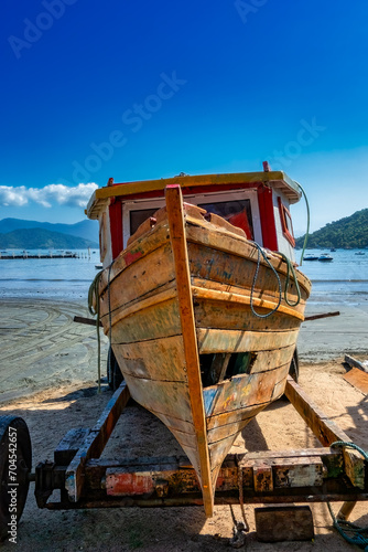 Old fishing vessel,Antique wooden boat. old fishing vessel on the beach sand for repair on a sunny day and blue sky