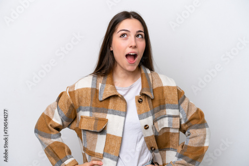 Young girl isolated on white background looking up and with surprised expression