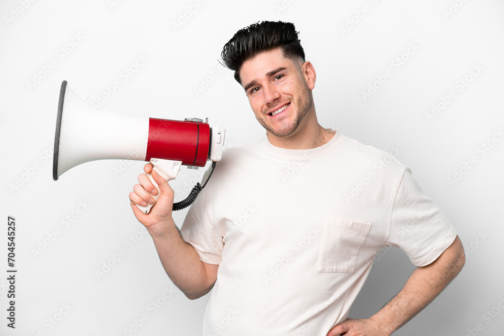 Young caucasian man isolated on white background holding a megaphone and smiling Young caucasian man isolated on white background holding a megaphone and smiling