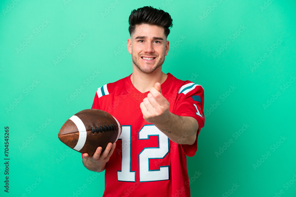 Young caucasian man playing rugby isolated on green background making money gesture
