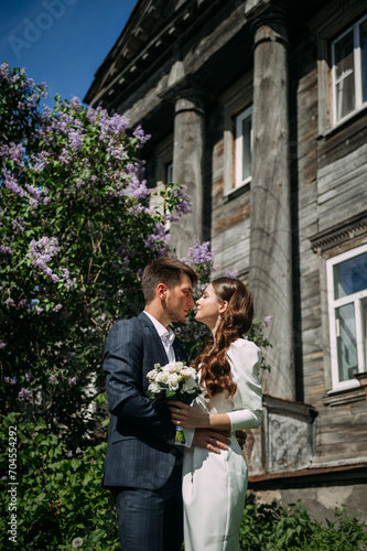 A man and woman in wedding attire. They are outdoors and the woman is wearing a wedding dress 5073.