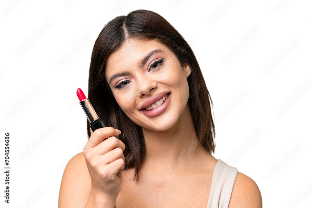 Young Russian woman with rainproof coat and umbrella over isolated chroma key background holding red lipstick Young Russian woman with rainproof coat and umbrella over isolated chroma key background holding red lipstick