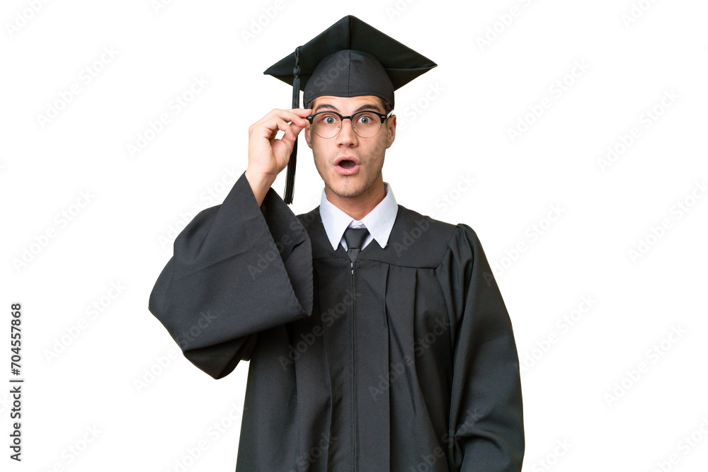Young university graduate caucasian man over isolated background with glasses and surprised Young university graduate caucasian man over isolated background with glasses and surprised