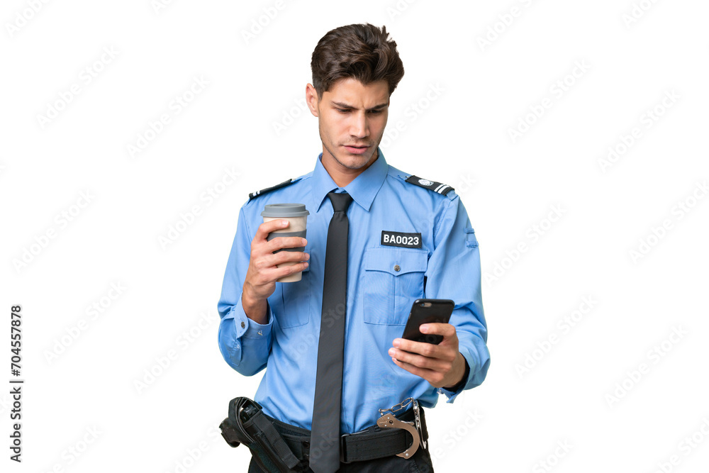 Young police man over isolated background holding coffee to take away and a mobile Young police man over isolated background holding coffee to take away and a mobile