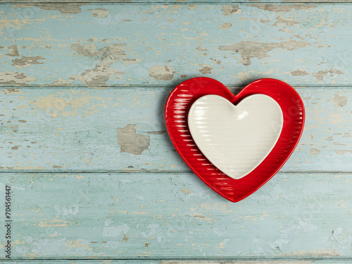 Heart shaped plates on vintage wooden background. Top view.