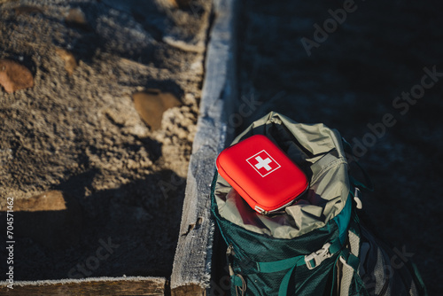 First aid kit is on the backpack, first aid on the trip, trekking in the mountains, personal equipment, first aid kit. photo