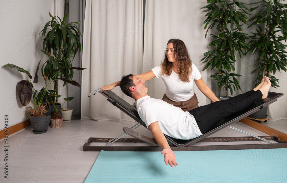 Relaxed man learning yoga poses with teacher Relaxed man learning yoga poses with teacher