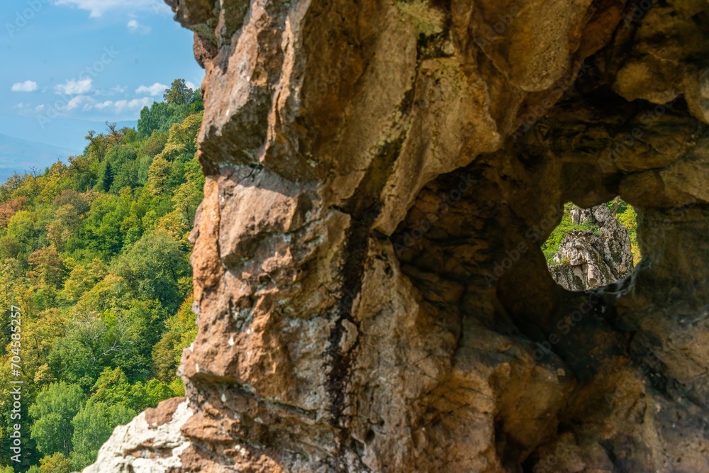 rock with a natural window in a cave overlooking the mountain slope of the Western Caucasus (South Russia)