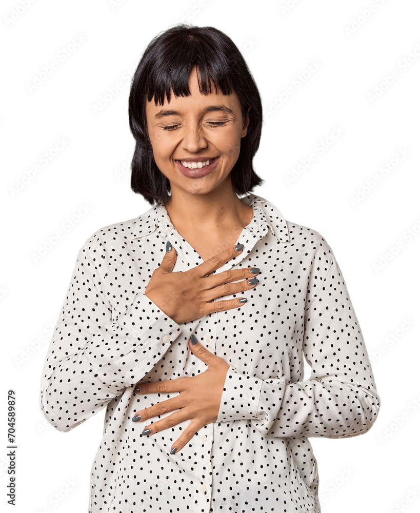 Young Hispanic woman with short black hair in studio laughs happily and has fun keeping hands on stomach. Young Hispanic woman with short black hair in studio laughs happily and has fun keeping hands on stomach.